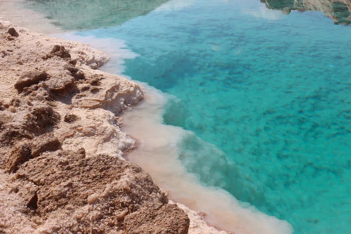 Turquoise salt-lake water along the shore of Siwa Oasis