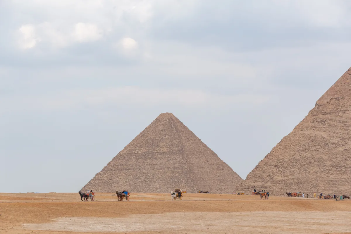 Pyramids of Giza seen across the open desert plateau