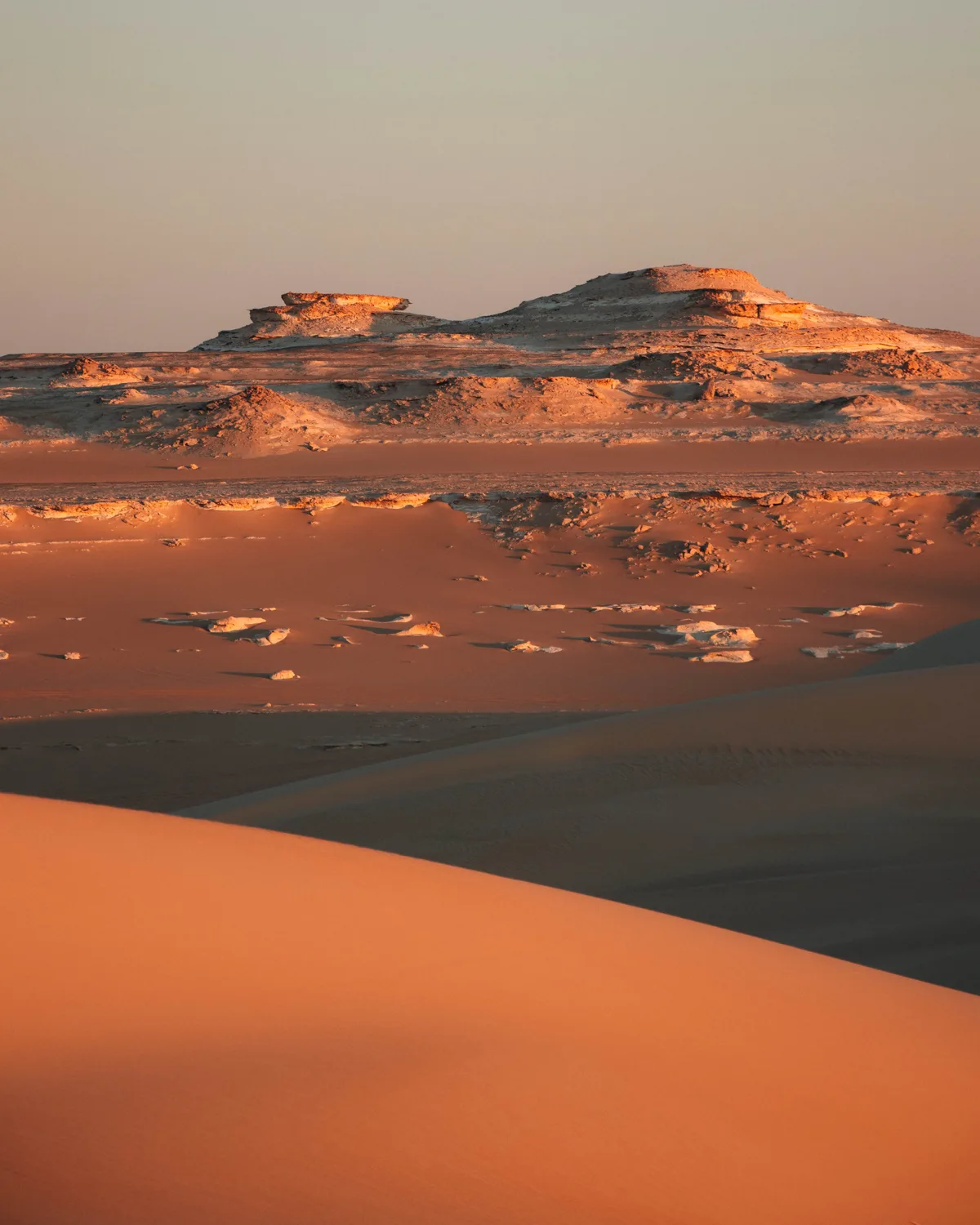 Layered sand dunes and rocky formations in the Siwa desert