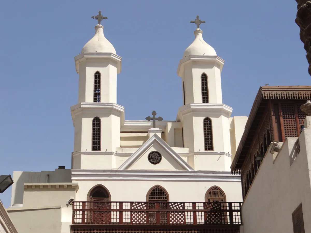White Coptic church facade with twin bell towers in Cairo