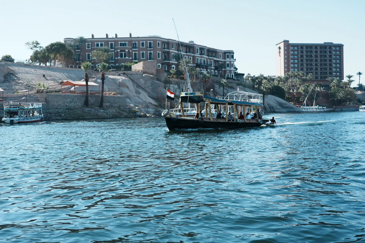 Traditional felucca near the inhabited Nile riverbank at Aswan