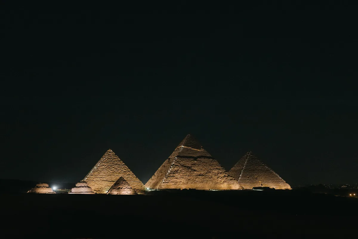 Wide night view of the illuminated Giza pyramids